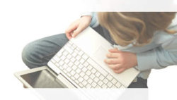 Foto: Frau sitzt über Laptop